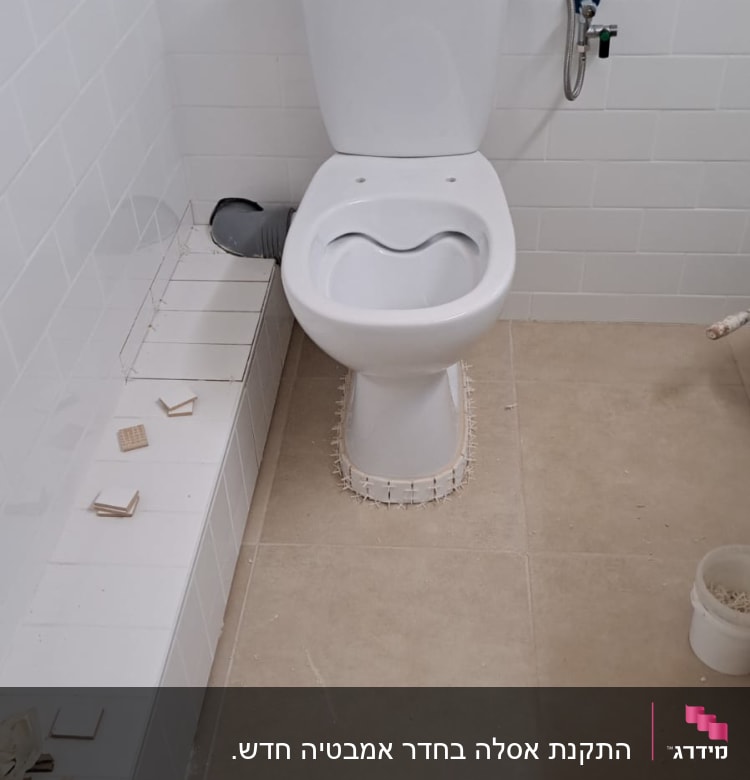 אסלה מותקנת עם חיבורי צנרת גלויים
